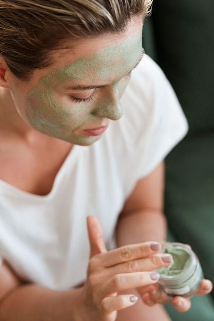 High view woman applying organic facial mask