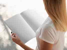 Free photo high view woman holding a mock-up magazine