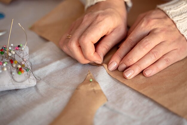 High view woman sewing with needle and thread