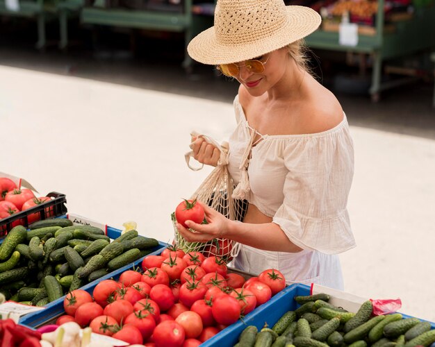 High view woman using organic bag for veggies