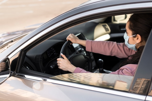 High view woman wearing medical mask and driving