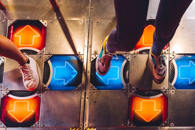 High view women playing dancing arcade