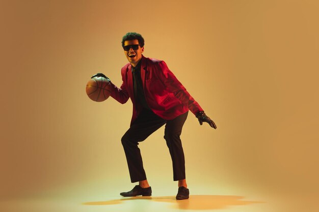 갈색 배경 위에 농구를 하는 빨간 재킷을 입은 하이패션 스타일의 남자