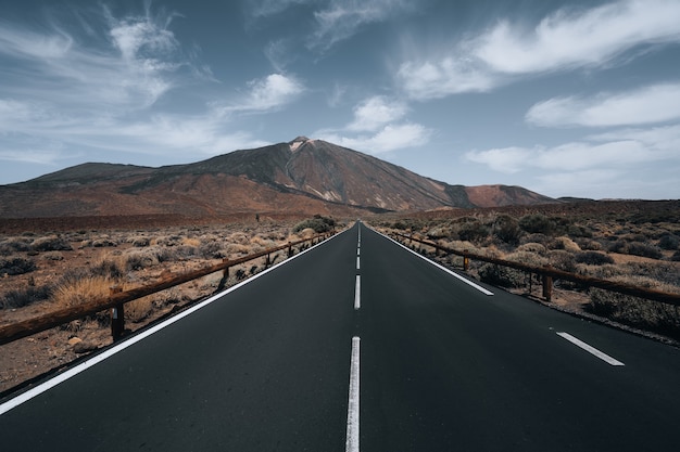 免费照片公路被山包围在多云的天空下