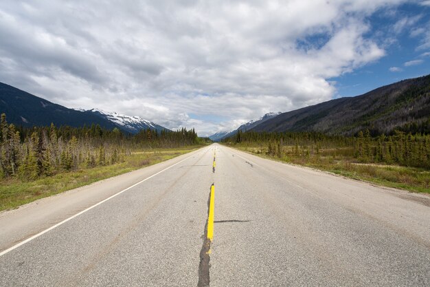 캐나다의 흐린 하늘 아래 산악 풍경으로 둘러싸인 고속도로