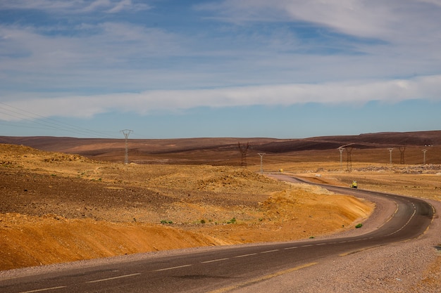шоссе в окружении песчаных холмов с электростанциями