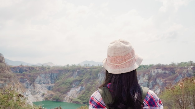 ハイカーアジアのバックパッカーの女性は山の上に歩いて、女性は自由を感じてハイキングアドベンチャーで彼女の休日を楽しんでいます。