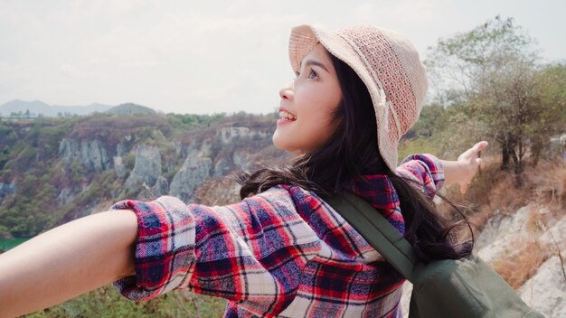 Hiker Asian backpacker woman walking to top of mountain, Female enjoy her holidays on hiking adventure feeling freedom. 