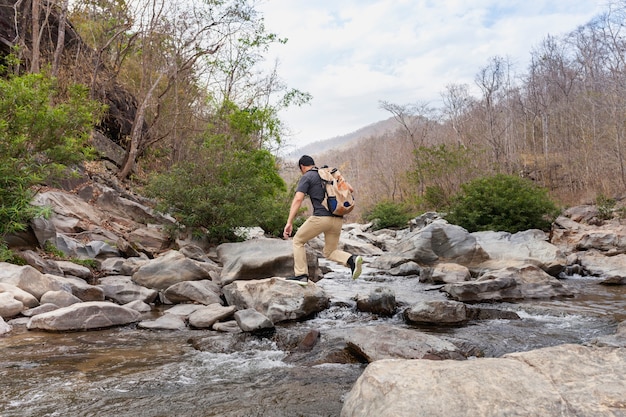 Free photo hiker crossing wild river