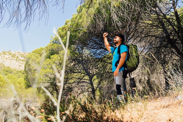 Free photo hiker in forest raising fist