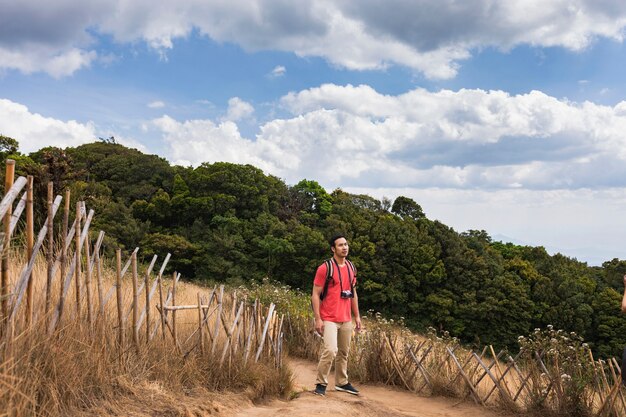 空を見上げている丘の上の登山者