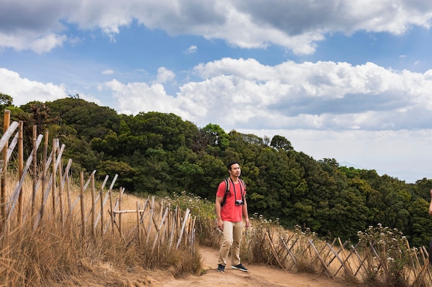 空を見上げている丘の上の登山者