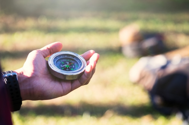 Hiker searching direction with a compass in the forest.