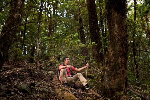 Hiker sitting on hill in jungle