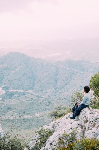 Турист сидит на скале