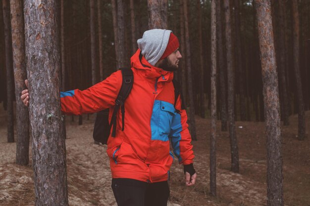 Hiker standing on sandy path beyond a tree