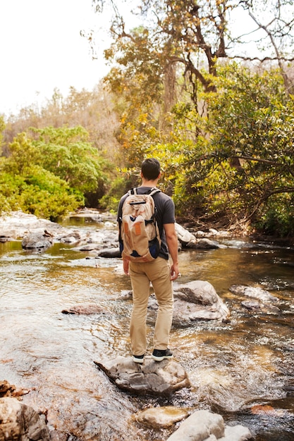 Free photo hiker standing on stone at river