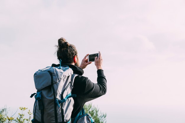 ハイカーが自然の中で写真を撮る