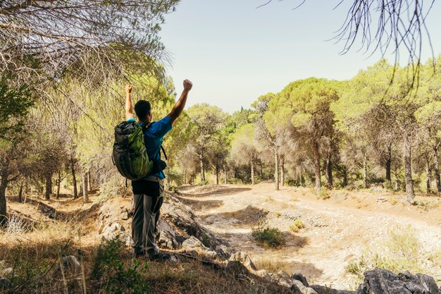 Hiker with backpack raising fist