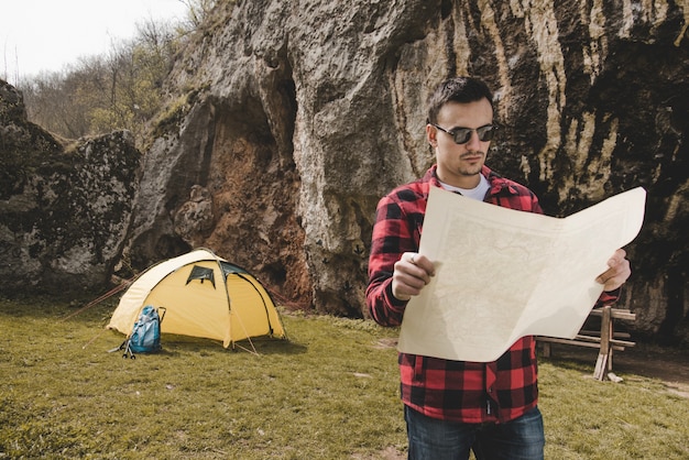 Escursionista con occhiali da sole e mappa