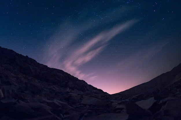 Free photo hill with a lot of metal pieces under the beautiful starry sky with aurora