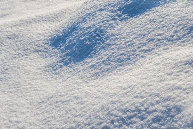 Hilly surface covered with fresh snow in the garden on a sunny day natural winter background