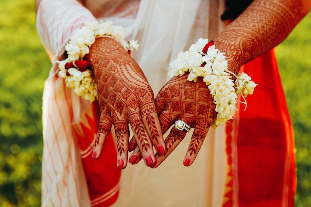 ヒンズー教の花嫁はヘナの入れ墨で覆われて彼女の手を示しています