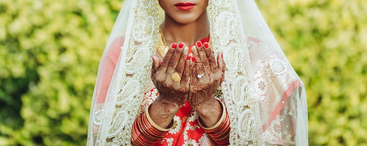 Free Photo hindu bride in white veil raises her hands up