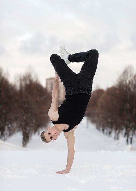 Hip hop performer standing on one hand outside