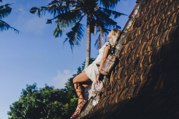 hippie girl with long blond hair in a dress on the roof.