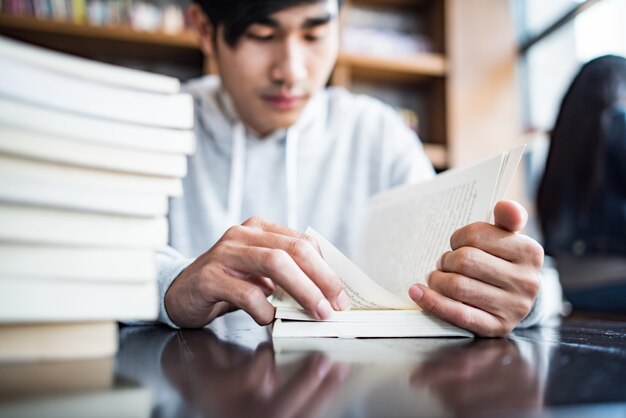 Hipster bearded man reading book in cafe.