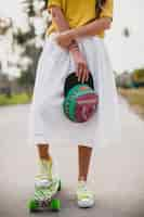 Free photo hipster cool woman with skate board and cap posing smiling on vacation