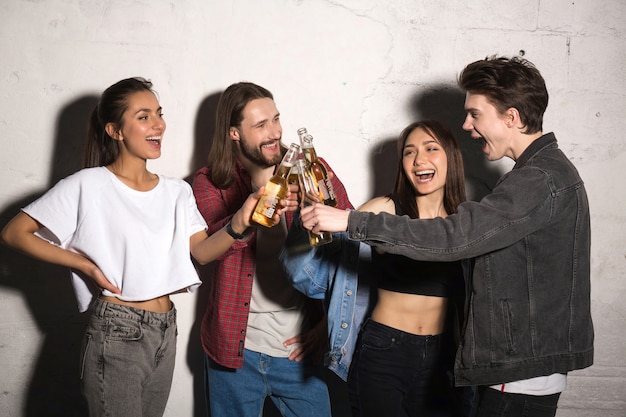 Free photo hipster friends standing together drinking beer.