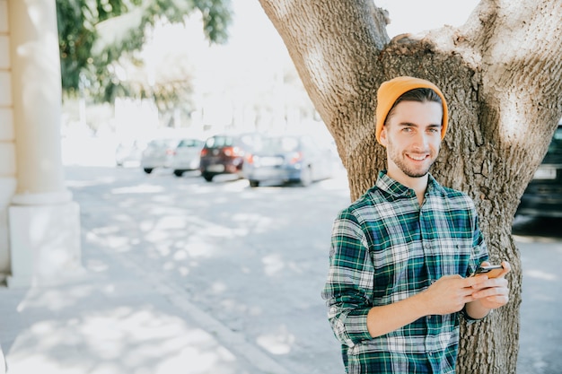 Foto gratuita pantaloni a vita bassa davanti all'albero