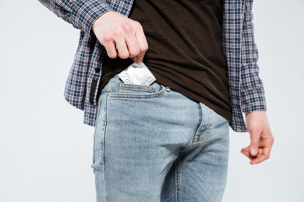 Hipster laying condom in pocket