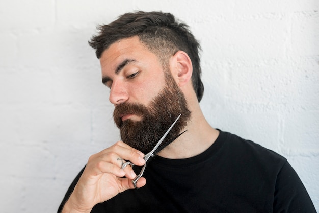 Barba di taglio maschile hipster con le forbici
