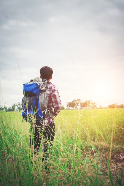 彼の肩の上にバックパックとヒップスターの男、TRAVELINを行く時間