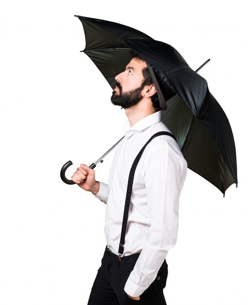 Hipster man with beard holding an umbrella