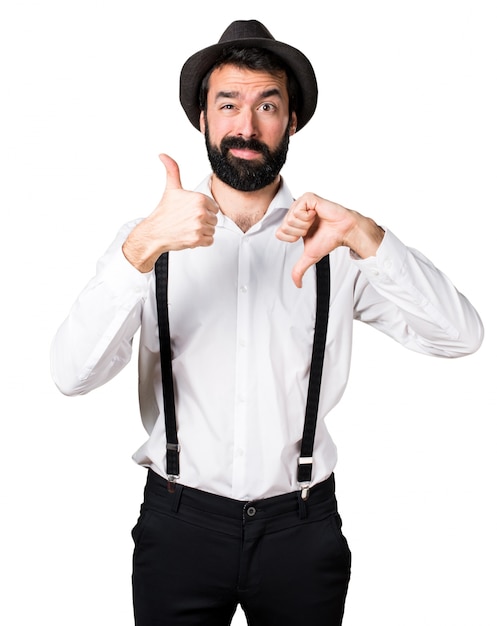 Hipster man with beard making good-bad sign