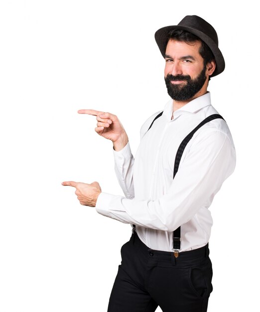 Hipster man with beard  pointing to the lateral