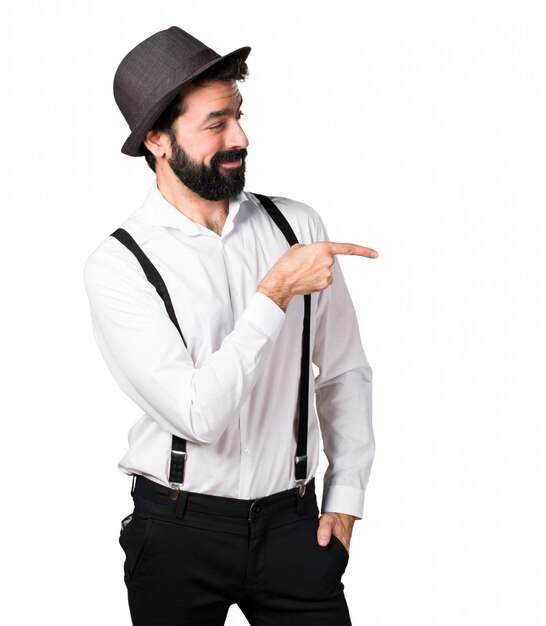 Hipster man with beard  pointing to the lateral