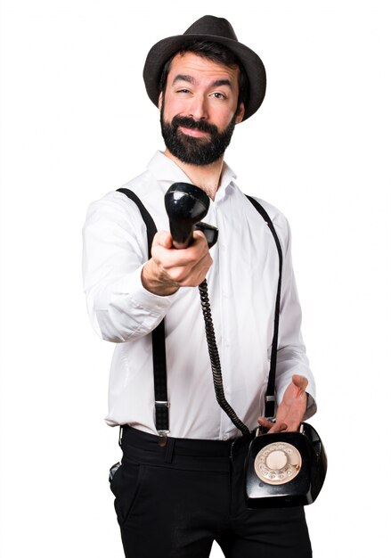 Hipster man with beard talking to vintage phone