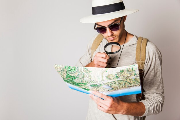 Hipster man with map and magnifying glass