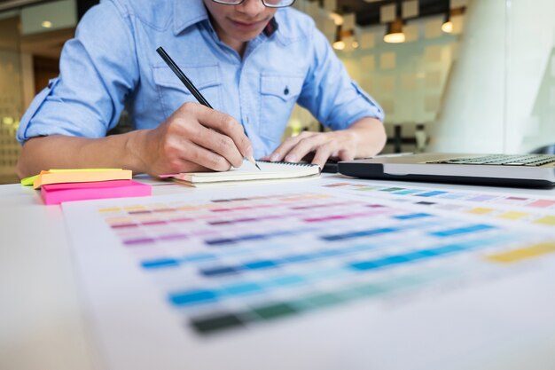 Hipster современный графический дизайнер, рисование рабочий дом, используя ноутбук в офисе.
