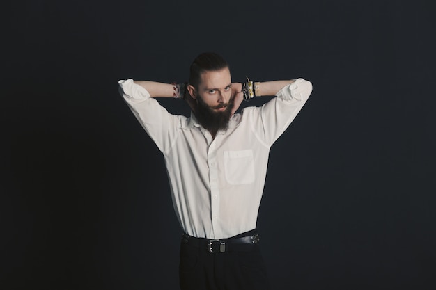 Hipster style bearded man white shirt in studio over black background