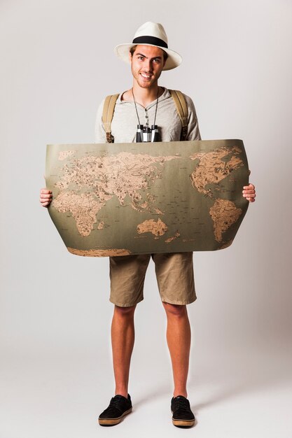 Hipster style tourist holding world map