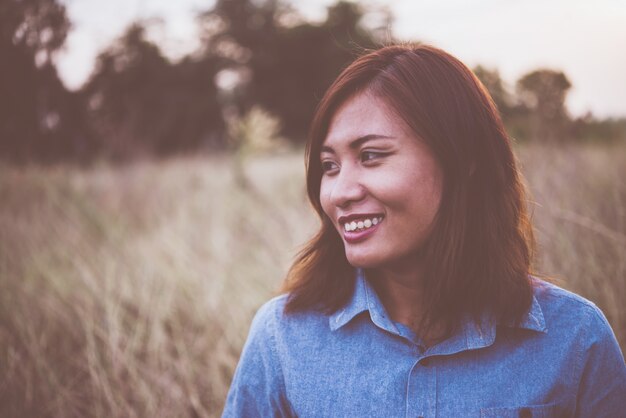 Hipster женщина улыбка прочь наслаждаться летом поле в вечернее время с классическим тональным фильтром.