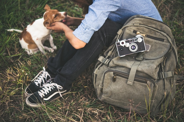 Foto gratuita hipster sorriso donna piace giocare con il suo cucciolo nel campo estivo, filtro toni vintage.