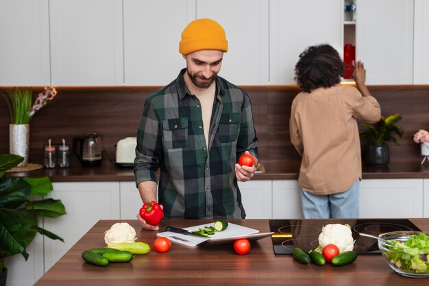 野菜を保持している流行に敏感な若い男