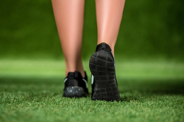 그의 발 신발에 아름 다운 여자는 잔디에 있습니다. 확대.